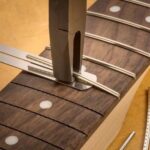 Alicate para Traste con Regla de Altura Luthier, en uso sobre un diapasón de guitarra.